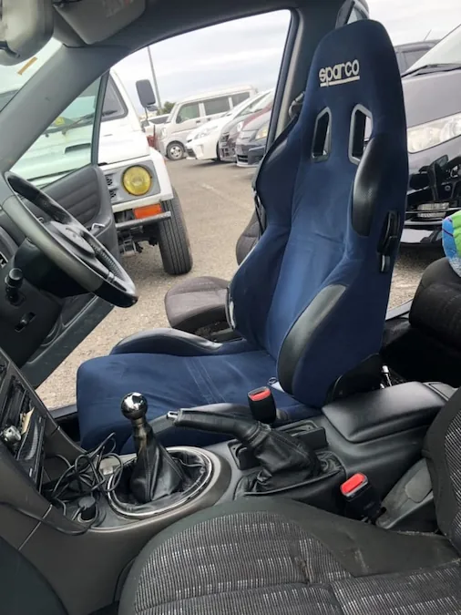 Interior view of a Toyota Altezza getting a blue racing seat upgrade.