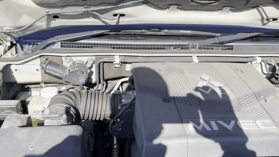 Detailed engine bay inspection of a Mitsubishi Pajero V6 MIVEC engine showing the intake manifold and technical components